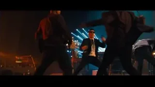 Man playing saxophone on stage with people — John Wick: Chapter 4