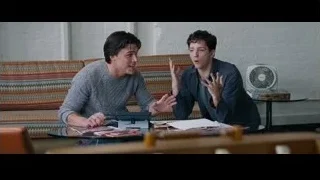 two young men talking at living room table — The Big Short