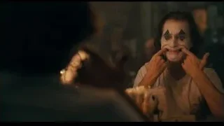joker-like man sitting at table — Joker