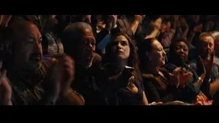 People cheering in a dimly lit auditorium — Now You See Me
