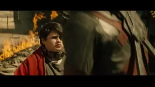 Young boy in red jacket by rubble fire — Deadpool 2