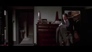 man in suit on bed with suitcase — American Psycho