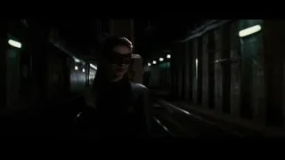 Woman in mask in dimly lit hallway with train — Batman: The Dark Knight Rises