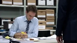Young man writing at desk in office — Suits