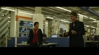man in suit walking through cubicles — The Social Network