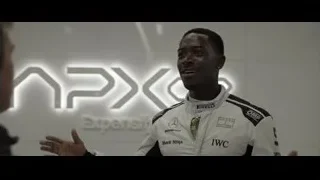 man in racing suit talking to another — F1