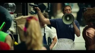 man speaking into megaphone to crowd outdoors — The Bear