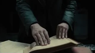 Person's hands holding open book — Blade Runner 2049