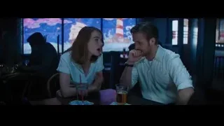 man and woman conversing at restaurant table — La La Land