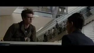 Man in green jacket talking to woman — The Amazing Spider Man