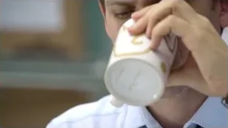 Man drinking from white coffee mug — Suits