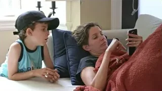 mother and son on couch looking at phone — Screened Out