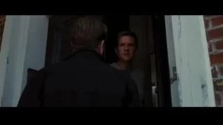 man standing in doorway of brick building — Batman: The Dark Knight Rises