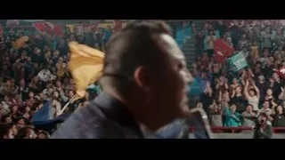 man speaking to crowd at rally with flags — The Karate Kid