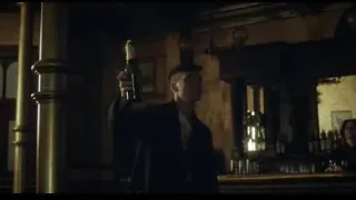 young man holding beer in dimly lit bar — Peaky Blinders