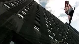 modern building with American flag flying — Suits