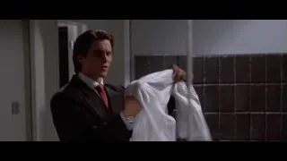 man in suit adjusting tie in room — American Psycho