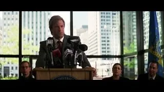 man speaking behind podium — Batman: The Dark Knight