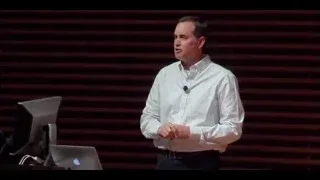 man giving presentation on stage with laptop — The Social Dilemma