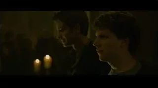 two men in dimly lit room with candles — The Social Network