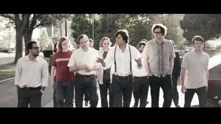 Men walking on street, one holding microphone — Jobs