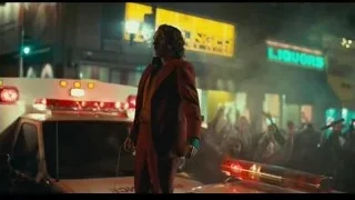 man in red jacket performing for crowd — Joker