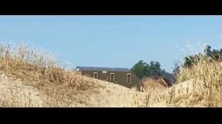 abandoned train car on sandy hillside — Cars 3