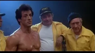 men in 'ROCKY' gear with shirtless man — Rocky III