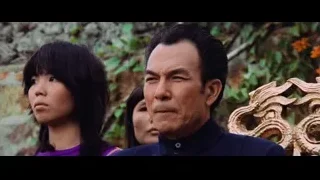 man speaking to woman by stone wall — Bruce Lee: Enter The Dragon