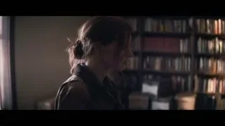 woman in dimly lit room with bookshelf — Interstellar
