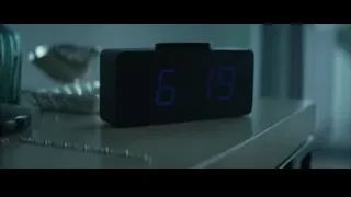 hand holding tongs over digital alarm clock — John Wick