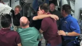 People embracing in space station — Elon Musk: Return to Space