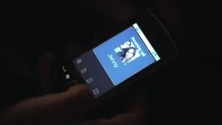 hand holding smartphone in dark — Suits