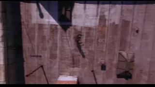 Man hanging from rope in alleyway — Spider Man